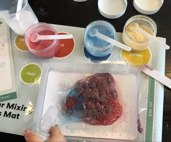 Toddler doing a chemistry experiment at home with a Kiwi Crate kit