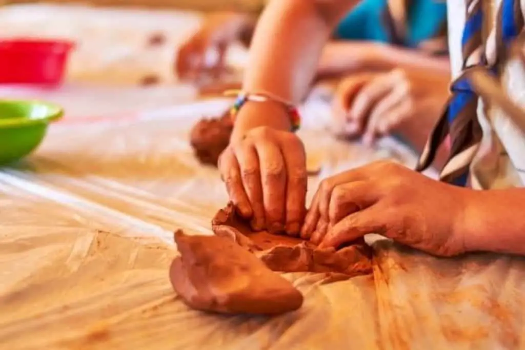 Children molding clay with paint
