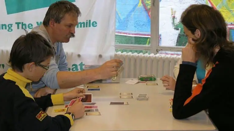People playing a small box board game