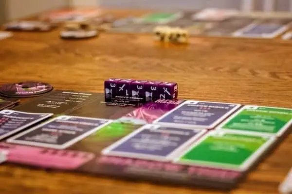 Board game with cards and purple dice