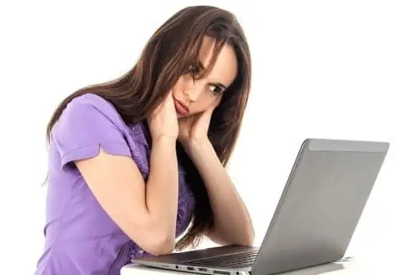 Girl looking frustrated while staring at laptop