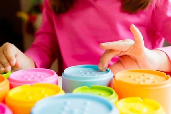 child with colorful sensory stacking cups