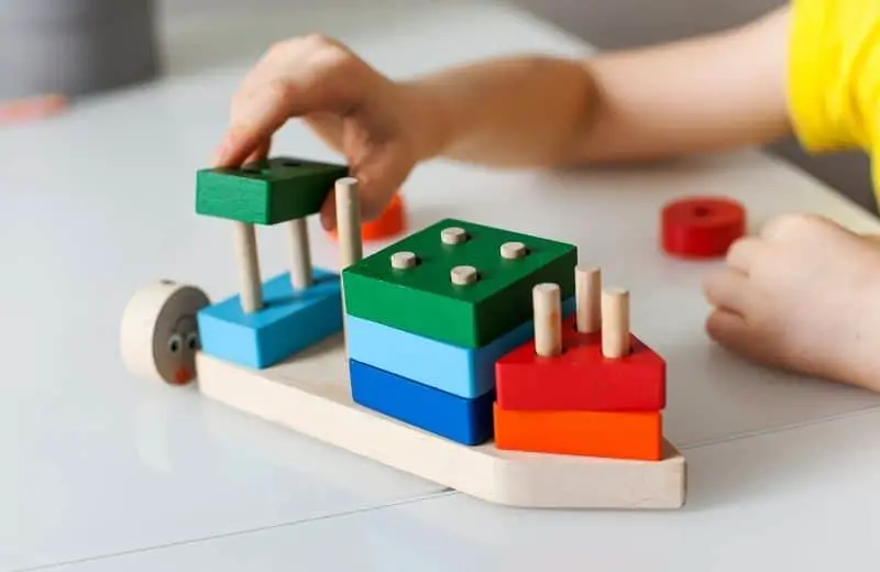 Childs hands playing with Montessori toys