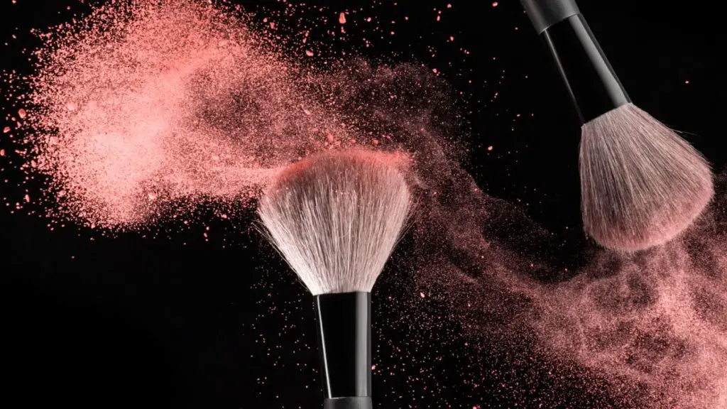 Two Makeup Brushes With Pink Powder