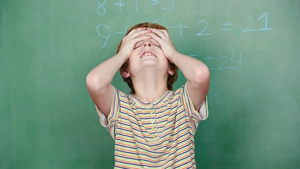 Boy In Front Of A Blackboard Being Frustrated With Math