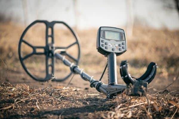 Black And Grey Metal Detector With A Digital Display Lying On The Ground